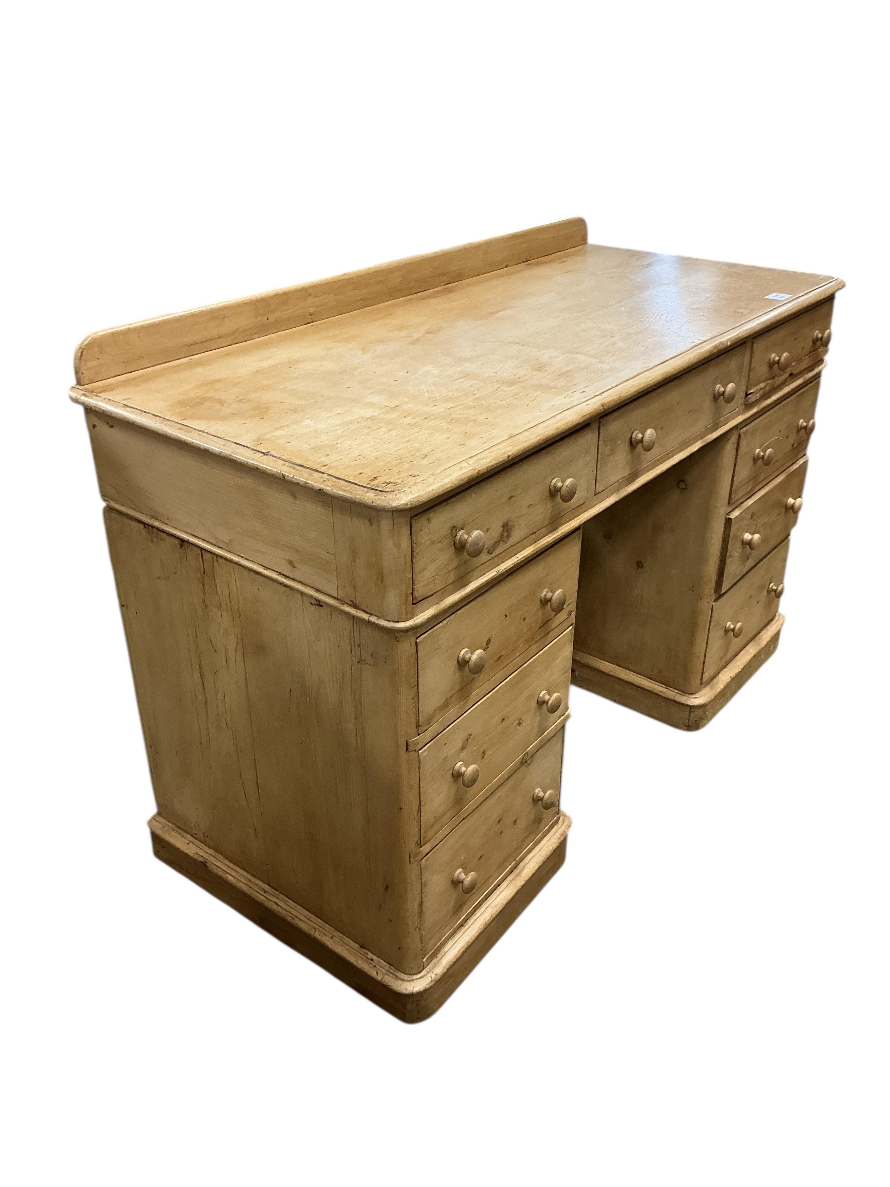 A Victorian pine pedestal desk, fitted with nine small drawers, width 122cm, depth 54cm, height 82cm